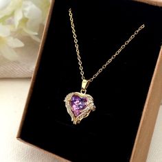 ✨ Discover the Magic of Elegance with Our Stunning Purple Heart Necklace! ✨ 💜 Fall in Love with Every Detail: This exquisite heart-shaped pendant features a mesmerizing purple gemstone, perfectly set in a luxurious gold-plated finish. Surrounded by sparkling crystals, it's designed to catch the light and dazzle from every angle. 🌟 Perfect for Every Occasion: Whether you're dressing up for a special event or adding a touch of glamour to your everyday look, this necklace is your go-to accessory. Luxury Heart-shaped Amethyst Jewelry, Gold And Purple Necklace, Purple Necklace As Valentine's Day Gift, Purple Heart Necklace For Anniversary, Purple Necklace For Valentine's Day Gift, Purple Heart Pendant Necklace As Gift, Purple Heart Pendant Necklace For Anniversary, Purple Double Heart Jewelry For Valentine's Day, Purple Jewelry For Valentine's Day Gift