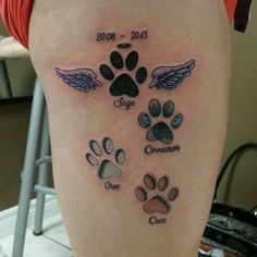 a person with a tattoo on their leg that has dogs paws and angel wings