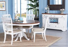 a dining room with blue walls and white furniture