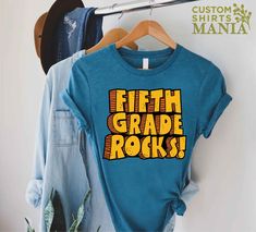 "5th Grade Rocks T-shirt, 5th Grade Teacher Shirt, Fifth Grade Shirt, Back To School Gift, Gift for Teacher, First Day of School Shirt, Fifth Grade Gift, Teacher Tee, 5th Grade TShirt, Back To School Shirt, Teacher Appreciation, 5th Grade Team Shirt, Hello Fifth Grade ----- How To Order ----- 1-) Please, check and review all the photos. 2-) Choose your t-shirt size and color. *Different styles of shirts may have different shades of same color choice due to different manufacturer brands. *For this reason, we recommend you to match shirts from the same styles if you want precisely matching colors (ex. Unisex, V-necks, Toddler, etc.). 3-) Click add to cart. You can go back to add more shirts. 4-)Click \"Proceed to check out\". 5-)When you check out, you can add a note to seller for any reques 5th Grade Team Shirts, School Tshirt Design Ideas, 5th Grade Teacher Shirts, 5th Grade Shirts, 5th Grade Shirt, Teacher First Day Of School, Teacher Apparel, School Spirit Shirts Designs, 5th Grade Teacher