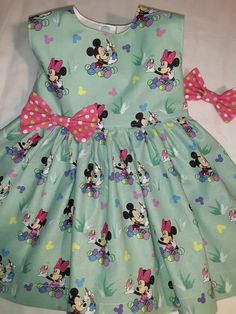 Fitted Sleeveless Dress For First Birthday, Playful Sleeveless Dress With Bow, Playful Fitted Minnie Mouse Dress, Playful Minnie Mouse Fitted Dress, Playful Minnie Mouse Summer Dress, Cute Green Dress For First Birthday, Playful Minnie Mouse Dress-up Dress, Playful Minnie Mouse Dress For Dress-up, Playful Sleeveless Easter Dress