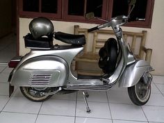 a silver motor scooter parked in front of a building