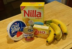 bananas, yogurt, and other ingredients on a wooden counter top next to a carton of nilla