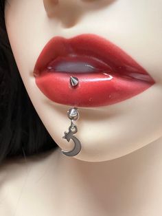 a close up view of a woman's face with red lipstick and silver earrings