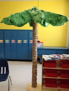 a palm tree is in the middle of a classroom with blue lockers and red bins