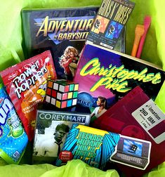 a basket filled with lots of different types of games and books on top of a green blanket