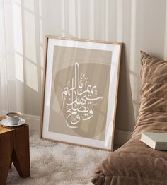 an arabic calligraphy is displayed in front of a bed with pillows and a coffee cup