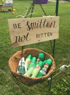 a wooden sign that says be smitten not bitten in front of some bottles