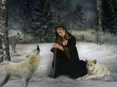 a woman sitting in the snow with two white wolfs and one is looking at her