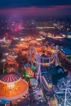 an aerial view of the fairground at night, with ferris wheel and carnival rides