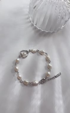 Add a touch of sophistication to your jewelry collection with this handmade freshwater pearl bracelet. Featuring natural, irregularly shaped pearls connected by a sleek silver chain, this piece exudes timeless charm and modern elegance. The delicate heart-shaped charm adds a romantic flair, making it a perfect accessory for any occasion. Features: Genuine freshwater pearls for a natural, unique look Stainless steel silver chain for durability and shine Heart charm accent for a subtle romantic touch Adjustable length to fit most wrist sizes This minimalist bracelet is versatile enough for casual wear or special occasions. It makes a thoughtful gift for birthdays, anniversaries, weddings, or just to show someone you care. Perfect for: Everyday elegance Bridal or bridesmaid jewelry Romantic g Pearls And Silver Jewelry, Homemade Bracelets, Bracelet With Heart, Pearls Bracelet, Bracelet Minimalist, Romantic Gestures, Freshwater Pearl Bracelet, Silver Chain Bracelet, Minimalist Bracelet