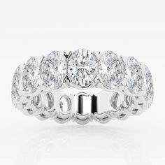 a white gold ring with three rows of round cut diamonds on the side and an oval band