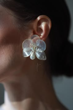 a close up of a person wearing some kind of earring with flowers on it