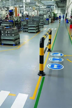 the inside of a factory with yellow and black poles