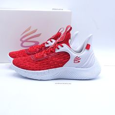 a pair of red and white sneakers in front of a box with the shoe logo on it