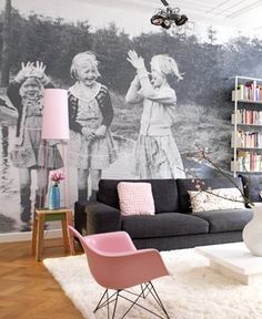 a living room filled with furniture and a large mural on the wall behind it's couches