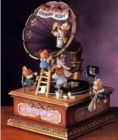 there are many figurines sitting on top of a musical box with a fan