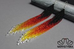 two pairs of beaded earrings with black and orange beads hanging from the end of each pair