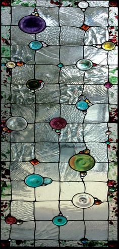 a stained glass window with many different colors and designs on it's side,