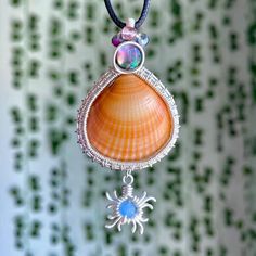 One of a kind, hand wire-wrapped pendant featuring an orange cockle shell (found off the fl shores), flashy abalone shell, mixed beads, & sun charm wrapped in plated silver. (Named after one of YOU.)💗 Free black necklace cord included; Made with love, as always.<3 Handmade Spiritual Shell, Handmade Shell Pendant In Ocean-inspired Style, Beach Wire Wrapped Shell, Wire Wrapped Shell Gift, Bohemian Wire Wrapped Shell As Gift, Bohemian Wire Wrapped Shell Gift, Handmade Ocean-inspired Abalone Shell, Bohemian Abalone Shell For Gift, Ocean-inspired Wire Wrapped Shell