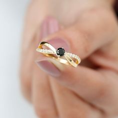 a woman's hand holding a black and white diamond ring