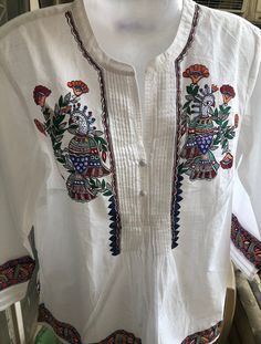 This is a beautiful, hand painted white kurta/kurti/traditional Indian pure cotton top. It has intricate colorful designs on a beautiful white base. It can be paired with jeans/pants or even your favorite skirt. Our artisan Rita painstakingly uses the traditional hand painted style called Madhubani from central India and it took her over a week to paint this unique top. The top is painted using a traditional Madhubani/Mithila technique from the Bihar state in India by our artisan, Rita who's fam Ethnic Kurti, Indian Tops, White Kurta, Unique Top, Yellow Painting, Cotton Tops, White Tops, White Painting, Pure Cotton