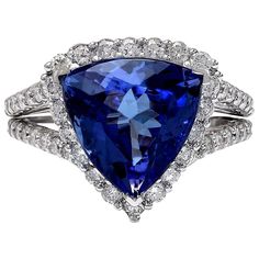 Introducing our stunning 7.07 Carat Tanzanite 14K Solid White Gold Diamond Ring. Crafted from luxurious 14K White Gold, this ring features a captivating trillion-cut Tanzanite weighing 5.41 carats, with dimensions of 11.00x11.00 mm, showcasing its mesmerizing hues. Adorning the sides are sparkling Diamonds weighing 1.66 carats in total, with a color range of F-G and clarity between VS2-SI1, adding brilliance and elegance. With a total metal weight of 4.9 grams and a face measurement of 14.50x14. Formal Tanzanite Trillion Cut Ring, Gia Certified Trillion Cut Diamond Ring For Formal Occasions, Gia Certified Trillion Cut Diamond Ring For Formal Events, Trillion Cut Sapphire Diamond Ring, Trillion Cut Diamond Ring With Gemstone For Formal Occasions, Formal Trillion Cut Diamond Ring With Gemstone, Elegant Gia Certified Trillion Cut Ring, Formal Trillion Cut Ring With Halo Setting, Formal Platinum Rings With Trillion Cut