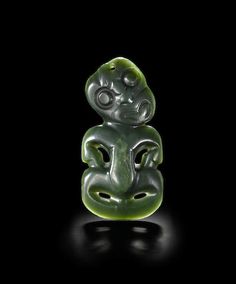 a green jade bead in the shape of a monkey