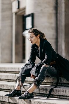 a woman is sitting on the steps outside