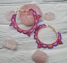 Handmade beaded hoop earrings with a unique tribal shape, these earrings feature a unique shape with a multicolored pattern inside. They were inspired by the shapes seen in art and architecture of Mesoamerican civilizations and the beautiful hot pink Frangipani flowers that grow there. They are another addition to the Daughters of collection. These hoops are depicted in a vibrant pink and purple motif but can be custom ordered in many colors. Alternate sizes can also be custom ordered. Feel free Traditional Multicolor Small Hoop Earrings, Traditional Small Hoop Multicolor Earrings, Unique Multicolor Small Hoop Earrings, Handmade Small Hoop Bohemian Beaded Earrings, Bohemian Purple Hoop Earrings With Round Beads, Purple Bohemian Hoop Earrings, Traditional Festival Beaded Hoop Earrings, Traditional Handmade Multicolor Hoop Earrings, Traditional Hoop Beaded Earrings For Festivals