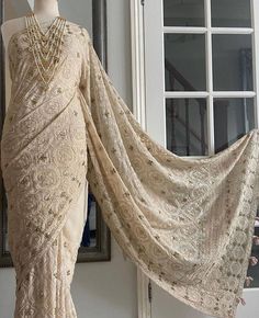 an antique dress on display in front of a window with a mannequin's head