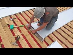 a man working on the roof of a house with wood shingles and plywood boards