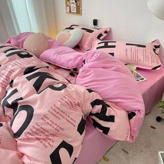 a bed covered in pink sheets and pillows