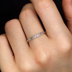 a woman's hand with a wedding ring on top of her finger, showing the band