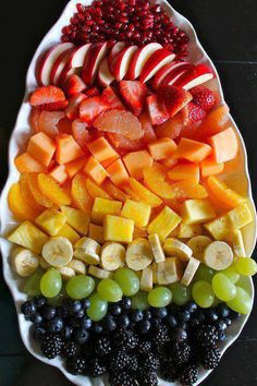 a platter filled with sliced fruit and berries