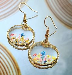 a pair of earrings with flowers in them