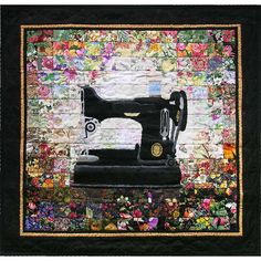 an old sewing machine sitting on top of a patchwork piece of cloth with flowers all over it