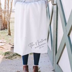 a woman standing in front of a door wearing a white towel with the words the mountains written on it