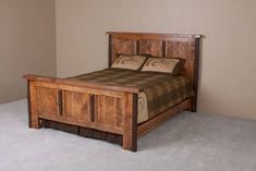 a wooden bed frame with two pillows on the headboard and foot board, in a bedroom