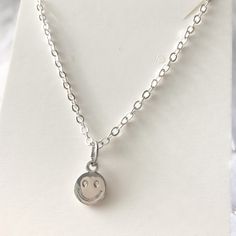 Silver smiley face necklace with a 5cm extended chain (total 45cm), so it is adjustable. This necklace is a hypoallergenic, minimalist and dainty necklace, perfect for layering with another chain! The pendant sits slightly above your breast bone. This is a handmade and packed by myself :) I also sell a gold version of this necklace which can be found on my Etsy! This has a stainless-steel chain, so it will not fade when it comes into contact with a little of water. In case your jewellery comes into contact with water/liquids, quickly take a cloth and wipe it dry, your necklace should not tarnish or oxidise! I would not recommend showering/ constantly exposing this necklace to water, to make sure the charm, the chain and other components keep their gorgeous shine! This charm is made of a zi Dainty Hypoallergenic Adjustable Charm Necklace, Dainty Adjustable Hypoallergenic Charm Necklace, Hypoallergenic Adjustable Dainty Charm Necklace, Trendy Nickel-free Sterling Silver Charm Necklaces, Trendy Sterling Silver Charm Necklace As A Gift, Simple Adjustable Charm Necklaces With Delicate Chain, Simple Adjustable Charm Necklace With Delicate Chain, Trendy Sterling Silver Charm Necklaces For Everyday, Trendy Sterling Silver Necklace For Everyday