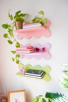 three shelves with books and plants on them