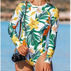 New Floral And Tropical Long Sleeve One Piece Swimsuit. Soft Cups Fixed Padding Zipper Raglan Sleeve Materials: 85% Polyester, 15% Spandex Lining: 90% Polyester, 10% Spandex Size: S 8-143 Green Summer Bodysuit For Surfing, Green Bodysuit For Surfing In Summer, Fitted Beachy Bodysuit For Spring, Beachy Fitted Bodysuit For Spring, Spring Beachy Fitted Bodysuit, Beachy One-piece Bodysuit For Spring, Spring Beachy One-piece Bodysuit, White Stretch Surfing Bodysuit, White Long Sleeve Surfing Bodysuit