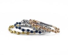 five different bracelets with gold, silver and blue beads