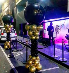 some black and gold balloons are in the street