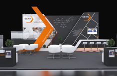 an exhibition stand with white chairs and orange accents