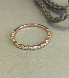 a gold ring sitting on top of a table next to a rope and some beads