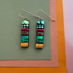 two pairs of earrings with different designs on them