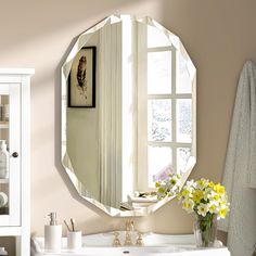 a bathroom with a white sink and large round mirror on the wall above it's counter