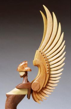 a wooden sculpture of a bird with wings and a mushroom on its head, holding a piece of wood