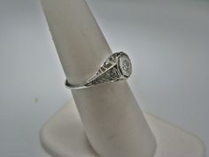 "For Sale: (1) H108 Gorgeous Diamond Ring in 14k White Gold from 1930's PLEASE READ ENTIRE DESCRIPTION BEFORE PURCHASING Please see pictures for more details! This stunning ring features a center 0.06 ct diamond. This is a beautiful filigree mounting down the side. The shank is decorated half way down. The ring is not stamped 14k, but was tested for it. This ring is from the 1930's. A beautiful piece for a any special occasion! What a great Gift! Specifics: *14k White Gold *Center Diamond approx Collectible Heirloom Solitaire Ring, Vintage White Gold Signet Ring With Center Stone, Vintage Solitaire Signet Ring, Vintage Diamond Solitaire Signet Ring, Vintage Diamond Cut Signet Ring For Wedding, Vintage White Gold Signet Ring, Vintage Oval Signet Ring With Brilliant Cut, Vintage Signet Ring For Anniversary With Round Cut, Vintage Wedding Signet Ring